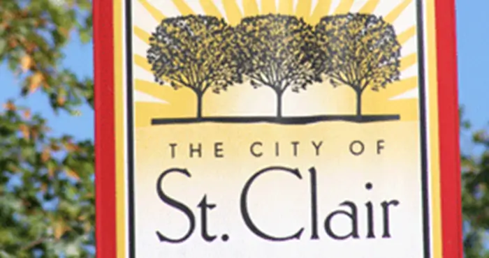 A tractor plows a sunlit field at dawn, creating dust while lush green crops flourish along the edge of the dirt path